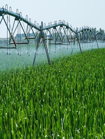 A large sprinkler system spraying water on a green field.